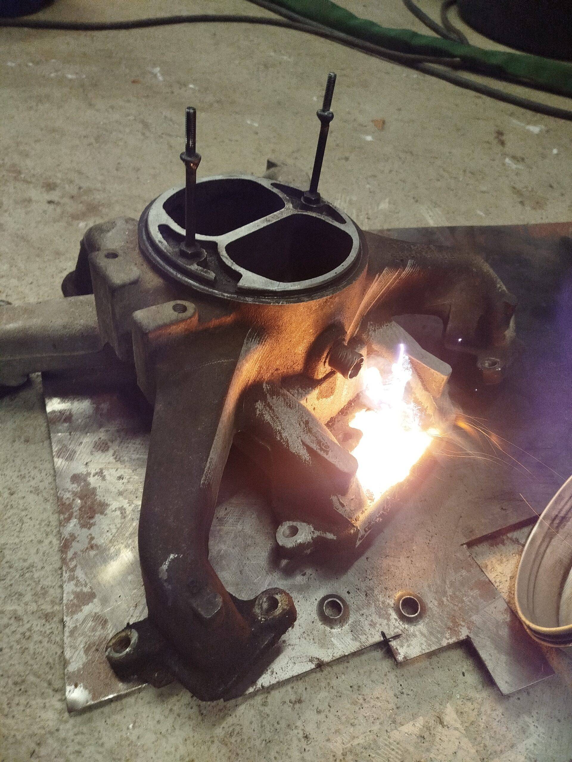 Laserreinigung von einem Ansaugkrümmer eines Chevrolet K30 Dieses Bild zeigt die Laserreinigung eines verdreckten Ansaukrümmers eines oldtimer. Es ist Feuer, Rauch, Licht und das Werkstück zu shene.
